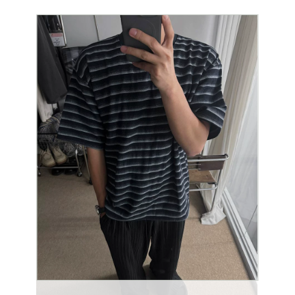 ブラックのストライプTシャツにネイビーのパンツ、デニムのバケットハットを被りスマホで鏡越しに自撮りする男性のフロントカット
