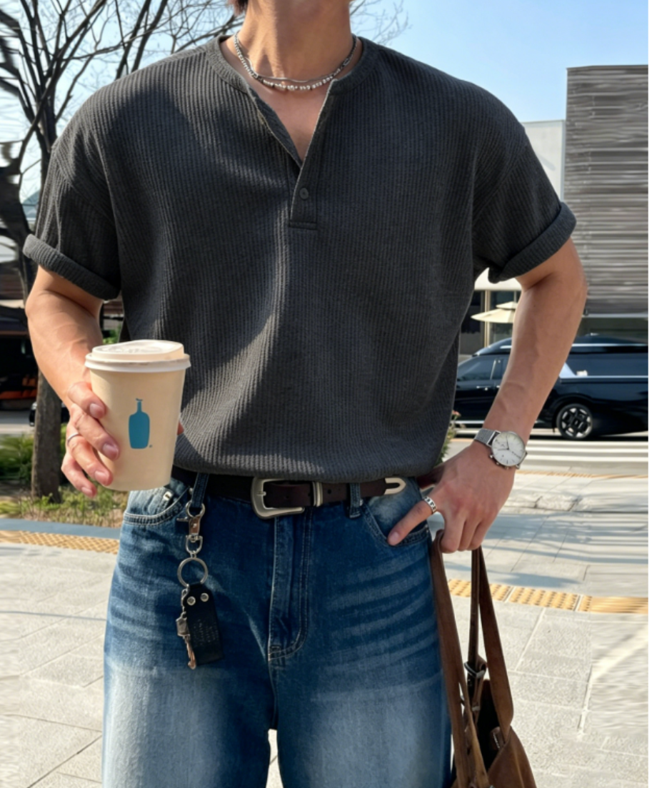 アイアングレーのワッフル生地のへンリーネックTシャツを着用した男性。