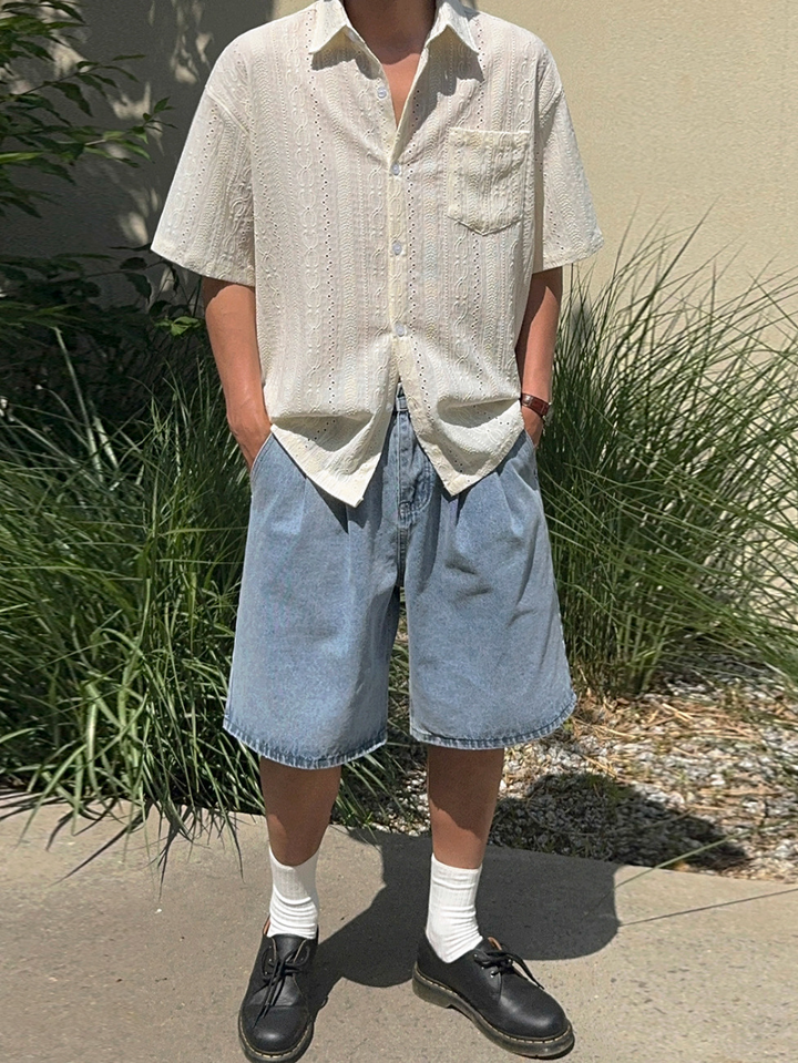 アイボリーのレースシャツ、ブルーのデニムハーフパンツ、白いソックス、黒の革靴を合わせた男性の全身コーディネート。