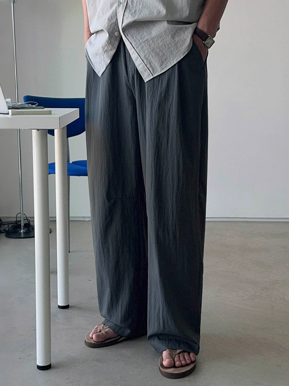 深めのタックが入ったダークグレーのナイロン風ワイドパンツを正面から捉えたローアングルカット