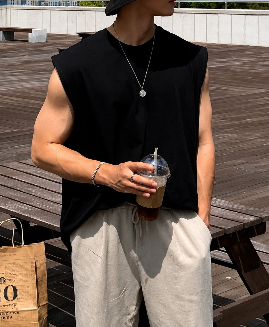 ブラックのノースリーブトップスにシルバーネックレスを合わせた胸元から腰元までの上半身アップカット。