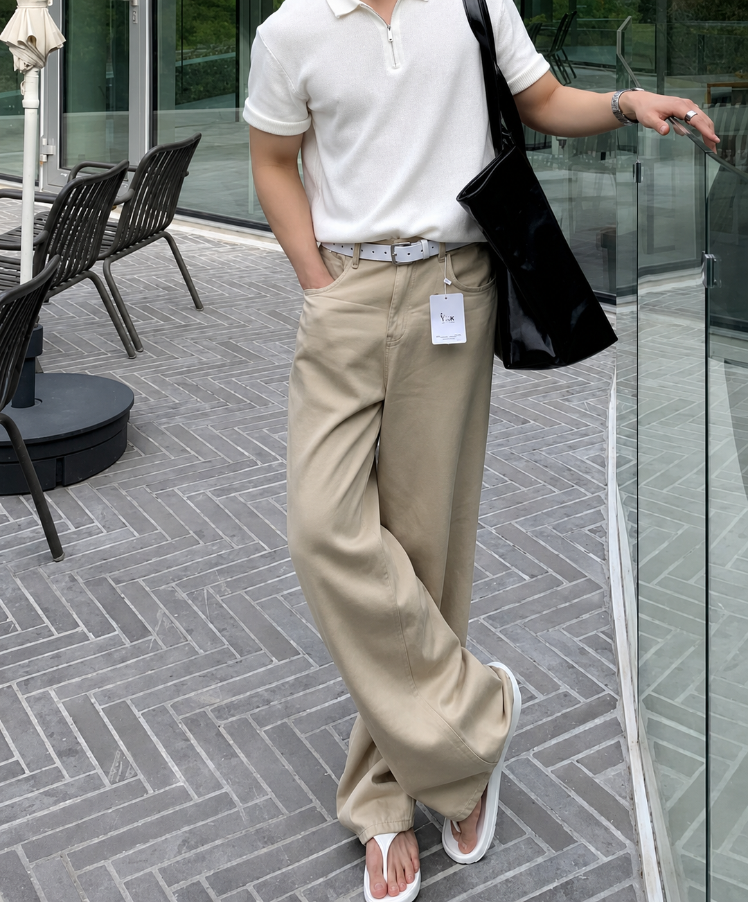 ホワイトのハーフジップニットポロにベージュのワイドパンツ、白のトングサンダルを合わせた、爽やかでリラクシーな夏のメンズ全身コーディネートカット。