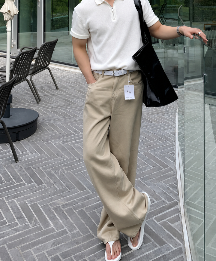 ホワイトのハーフジップニットポロにベージュのワイドパンツ、白のトングサンダルを合わせた、爽やかでリラクシーな夏のメンズ全身コーディネートカット。