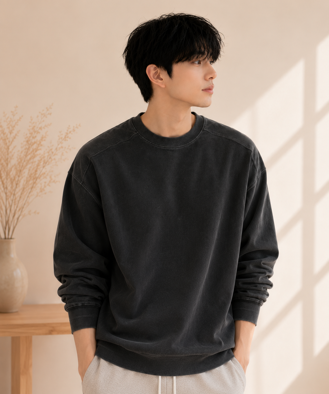 アイアングレーの長袖Tシャツにライトグレーのハーフパンツを合わせている男性の斜め前からのカット。