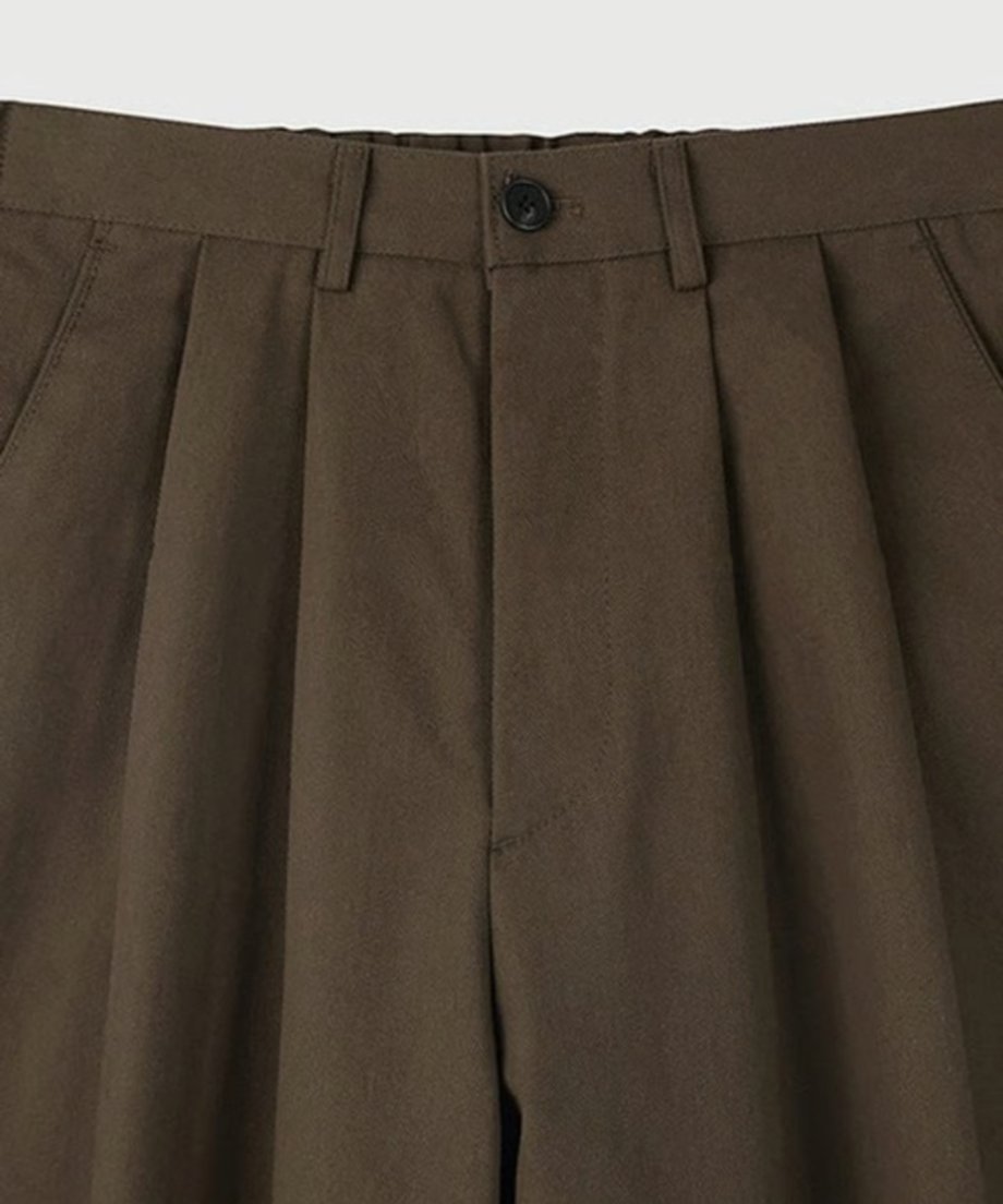 白背景に置かれた、ブラウンのツータックワイドスラックスの単体商品置き画カット。
