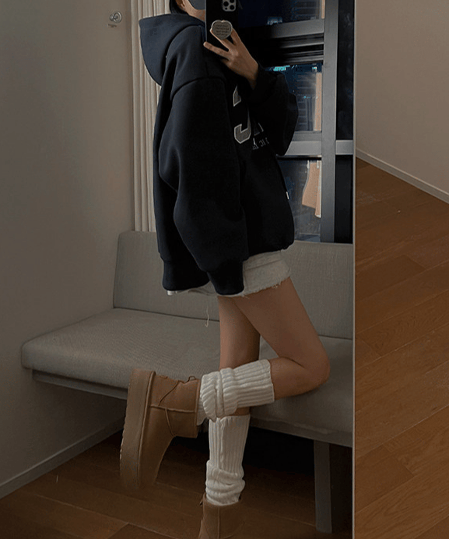 ネイビーブルーのパーカーに、厚底のムートンブーツと白のレッグウォーマーを合わせた、カジュアルで可愛い女性のサイドスタイルのコーディネート。
