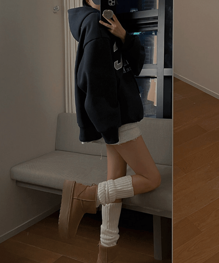 ネイビーブルーのパーカーに、厚底のムートンブーツと白のレッグウォーマーを合わせた、カジュアルで可愛い女性のサイドスタイルのコーディネート。