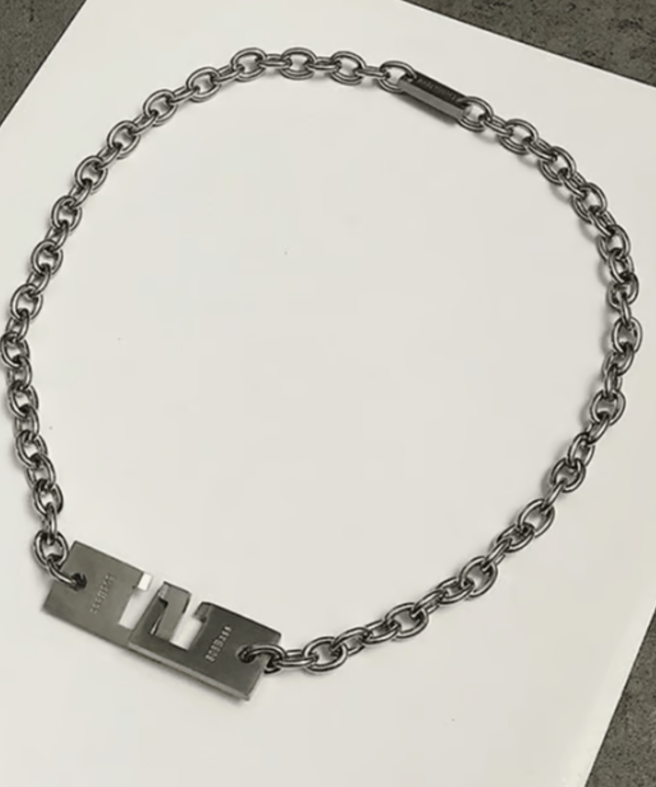 白いシートの上に円状に平置きされたメタルチェーンネックレスの物撮りカット。