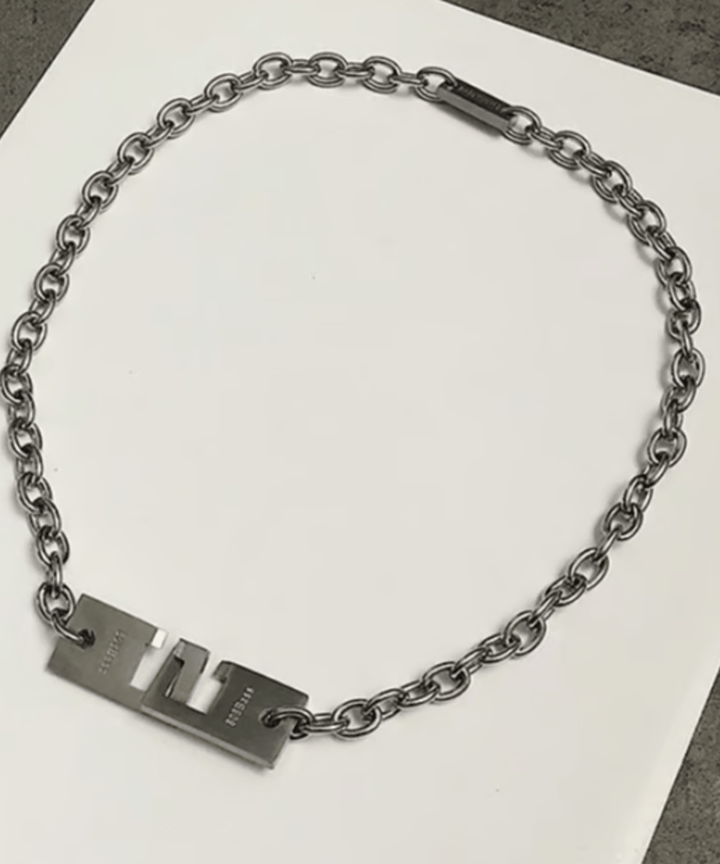 白いシートの上に円状に平置きされたメタルチェーンネックレスの物撮りカット。