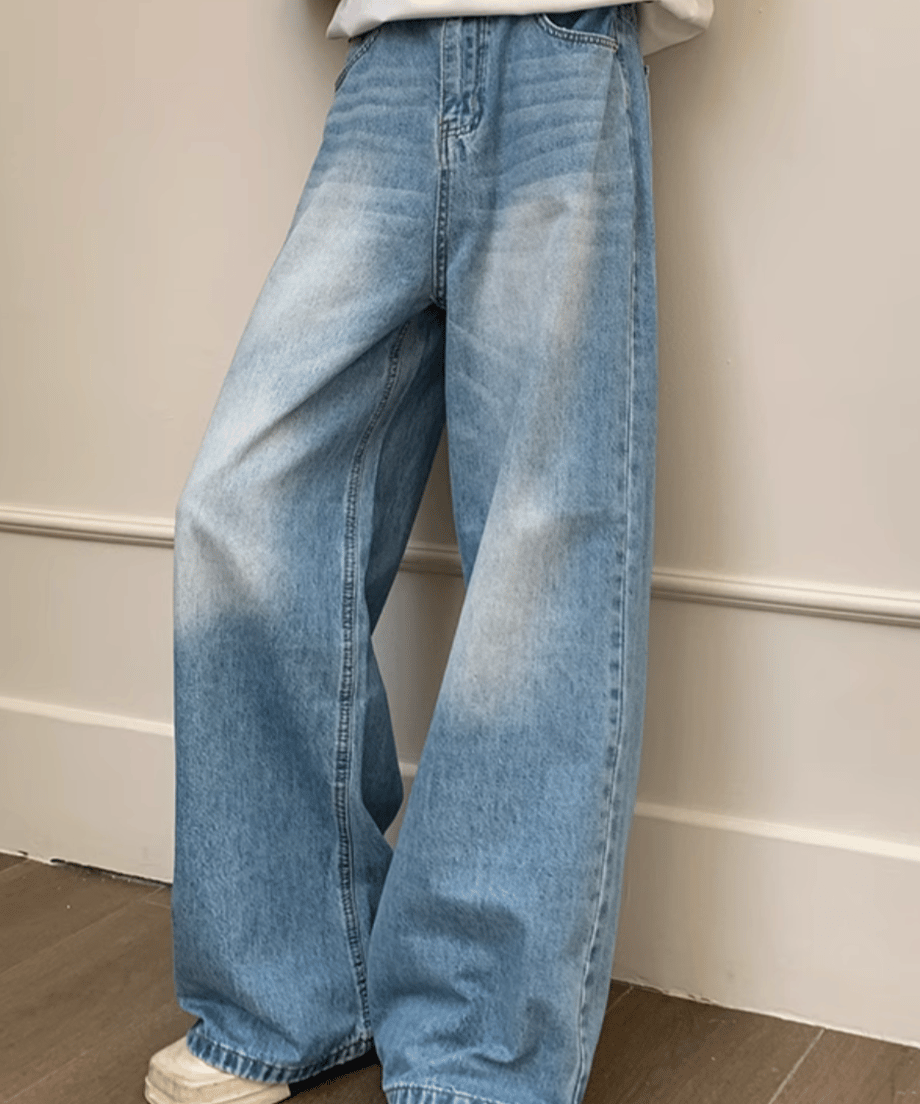 ライトブルーのワイドデニムパンツを着用した男性の正面（やや斜め）カット。