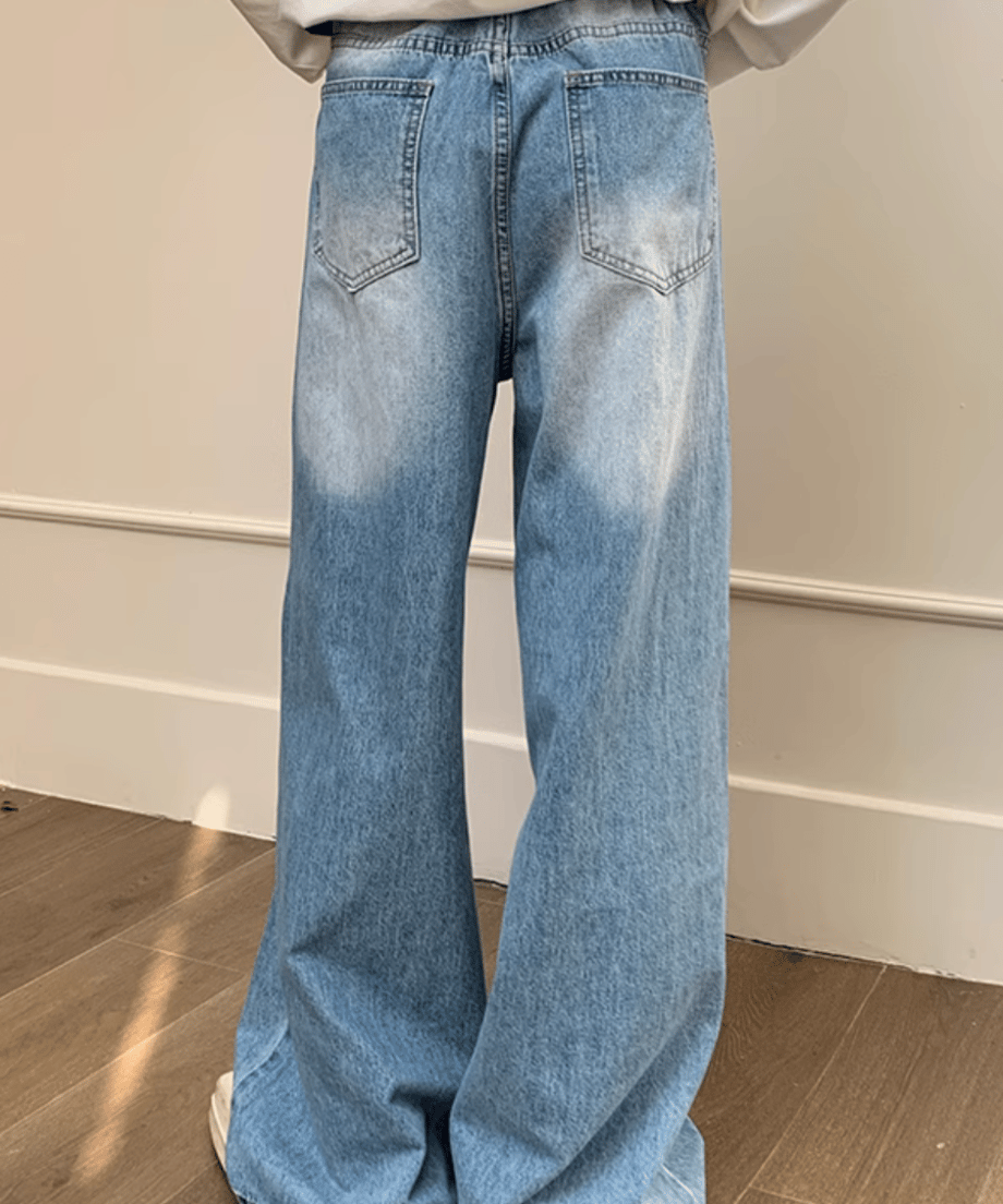 ライトブルーのワイドデニムパンツを着用した男性のバックスタイル（後ろ姿）。