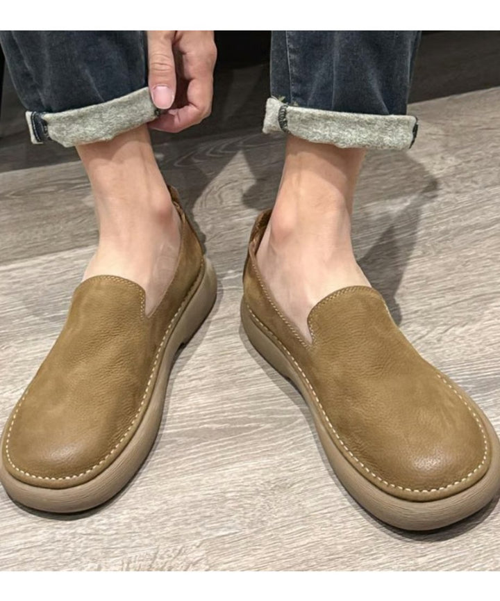 カーキのレザー調スリッポンシューズを着用した足元カット。