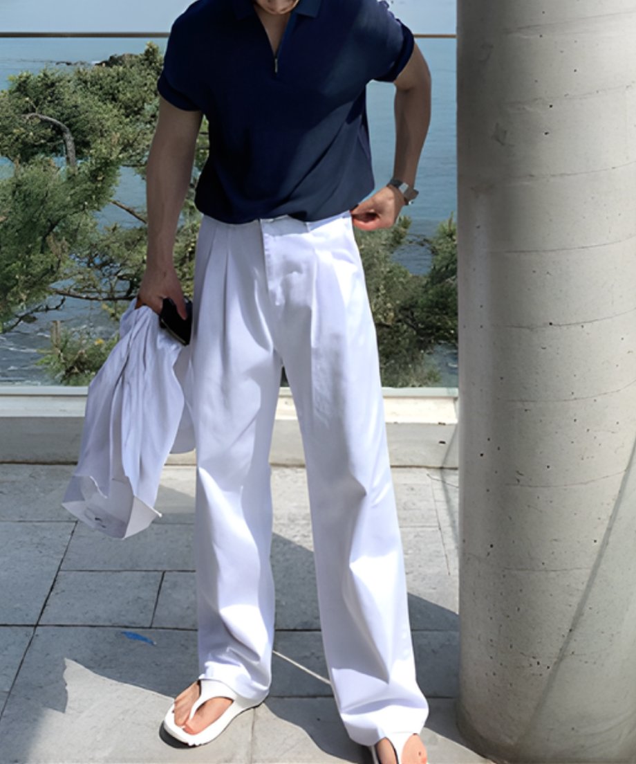 ネイビーのハーフジップサマーニットとクリーンな白のタックワイドパンツを合わせた、都会的で洗練された大人のリゾートスタイル。