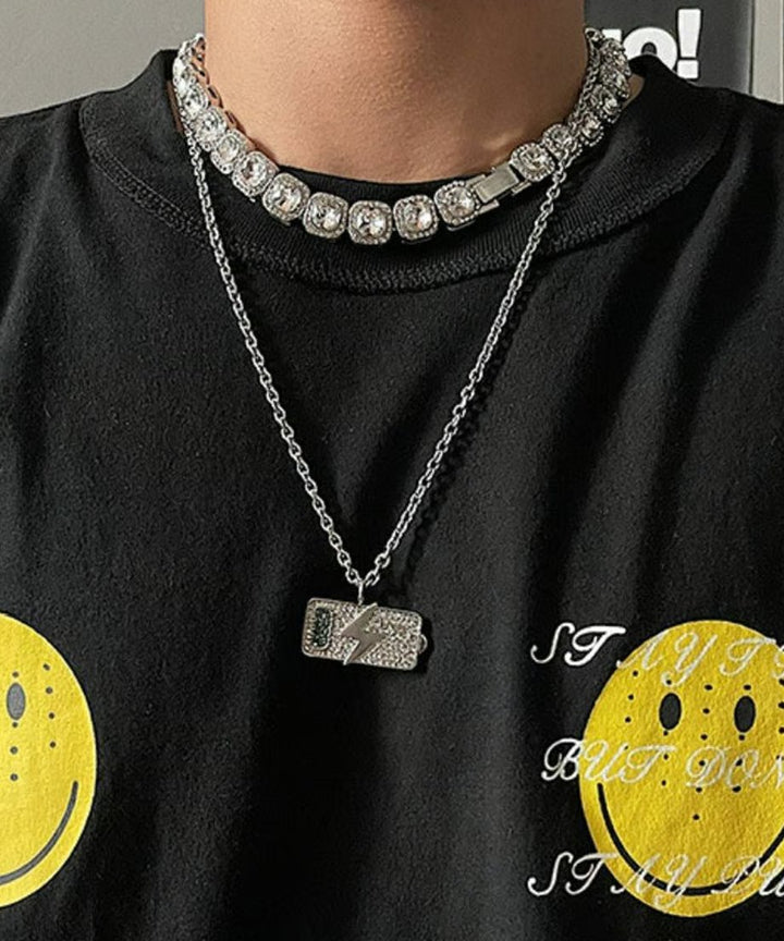 黒いTシャツの首元に、大粒のスクエアビジューネックレスと稲妻モチーフの細身チェーンネックレスを重ね付けしたメンズライクな着用カット。