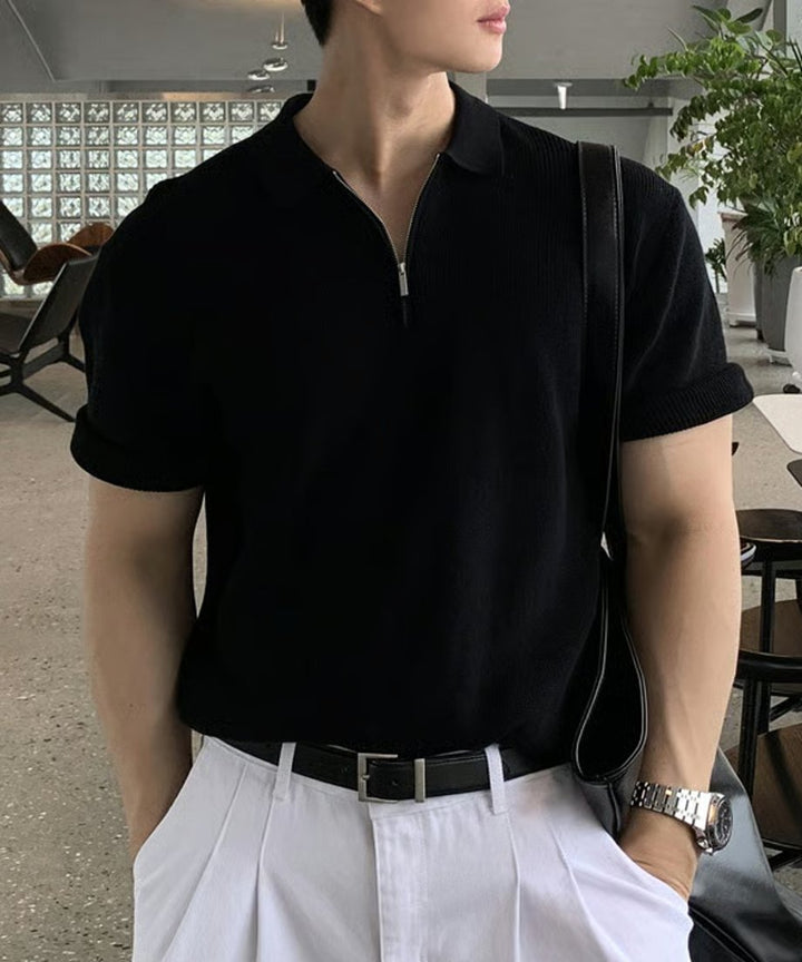 ブラックのハーフジップニットポロに白パンツをスッキリとタックインした、上品な大人のデイリーきれいめスタイル。