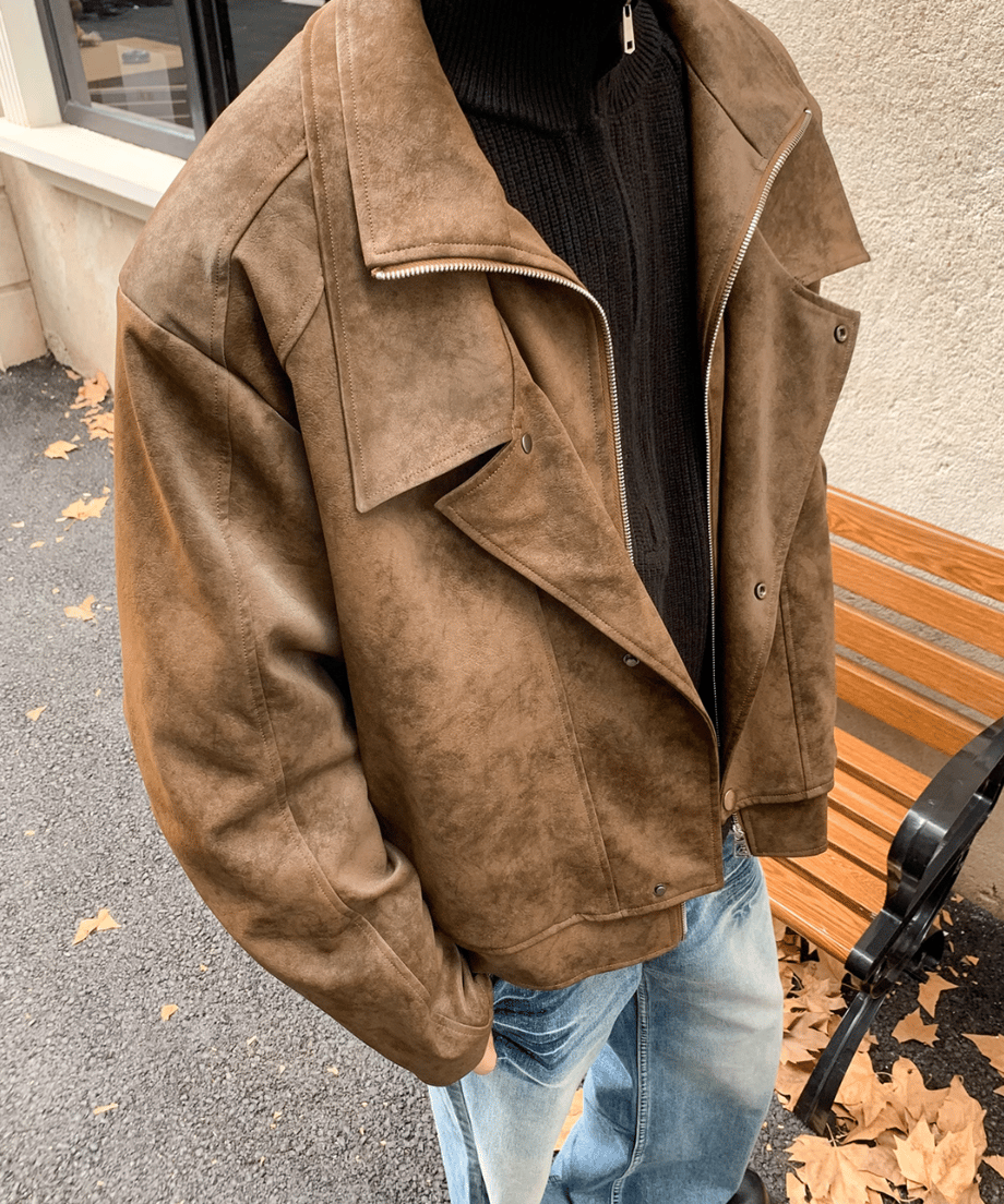コーヒーカラーのライダースジャケットを着用した男性の斜め上からの俯瞰（ふかん）アップカット。