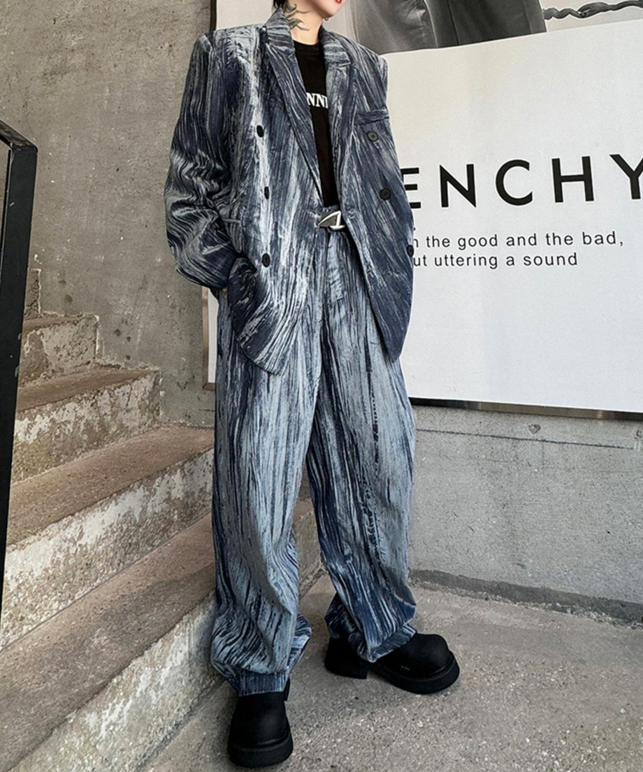独特の縦シワと光沢が特徴的なグレーのクラッシュベロアセットアップを着用した男性の全身カット。