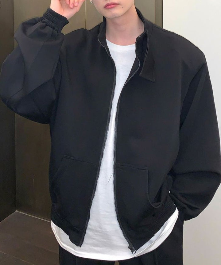 ブラックのブルゾンのジップを少し開け、裾から白いTシャツを覗かせた、こなれ感のあるメンズライクなストリートスタイルの上半身カット。