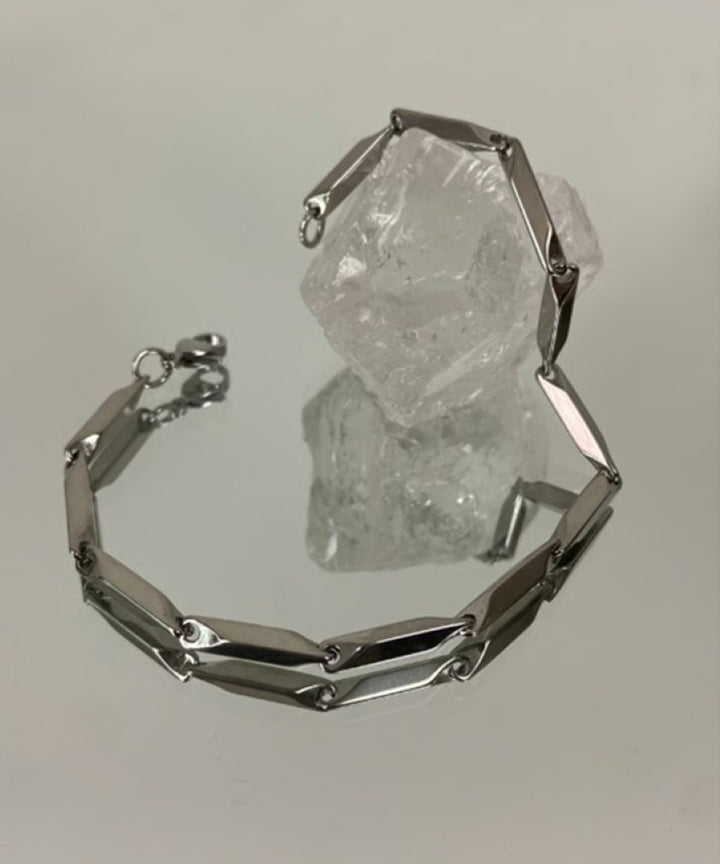 ミラーの上に置かれたブレスレットと透明な水晶の物撮り。