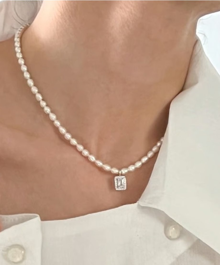 鎖骨ラインに美しく沿う、小粒パールとスクエアビジューのネックレスの斜めフロント