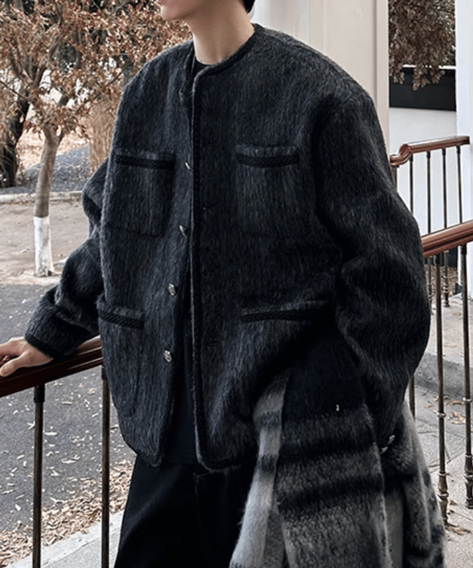 洋館のテラスの鉄製手すりに手をかける男性の横向きカット。