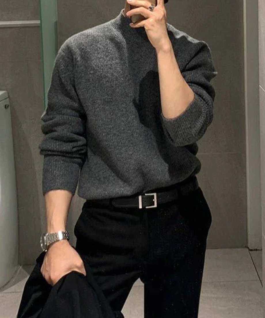 グレーのモックネックリブニットに黒のベルトとパンツを合わせた男性のフロント自撮りカット。