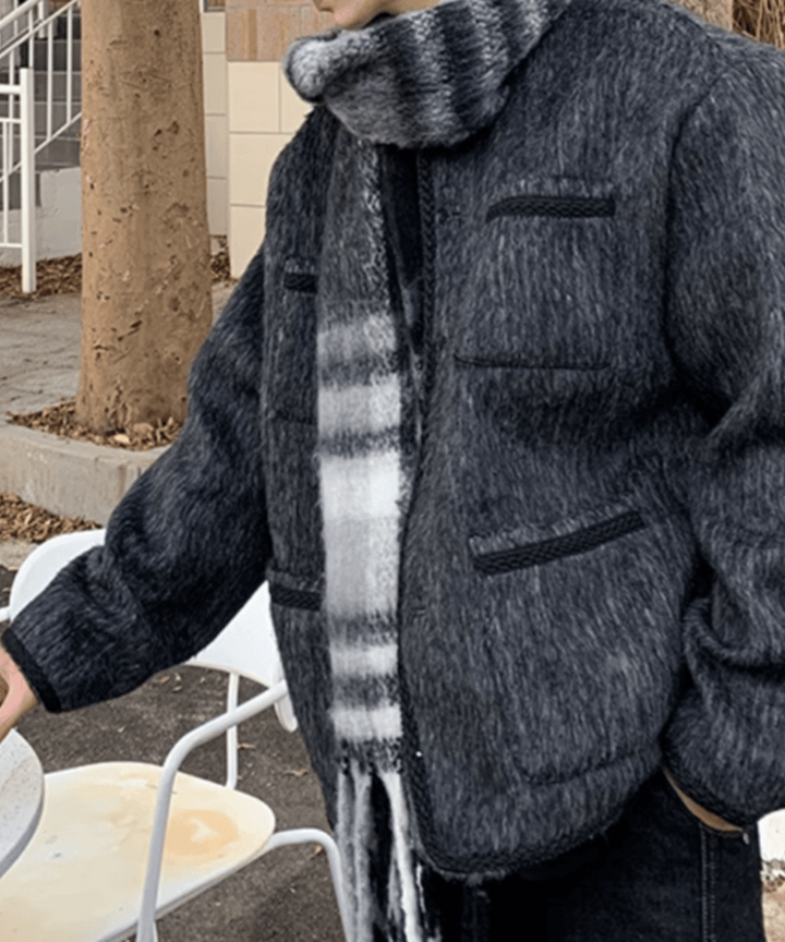 外の白いカフェチェアの横に立つ男性のサイドカット。