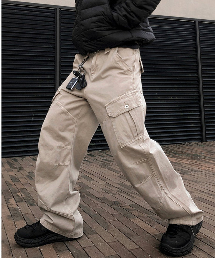 カーキのワイドカーゴパンツに黒のダウンジャケットを合わせ、歩みを進めている人物の斜めからの躍動感あるカット。