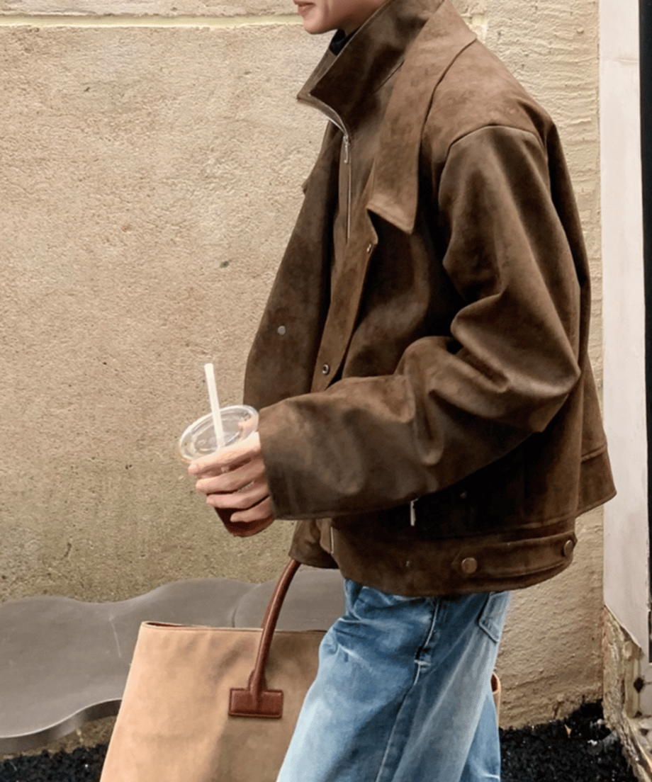 コーヒーカラーのジャケットを着用した男性の右側面からの歩行カット。