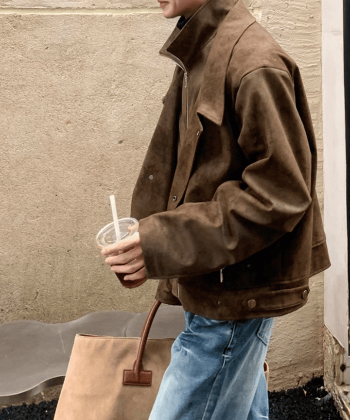 コーヒーカラーのジャケットを着用した男性の右側面からの歩行カット。