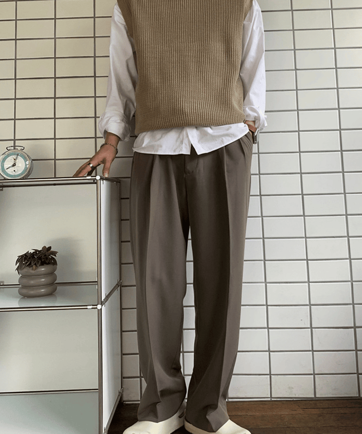 ベージュのクルーネックカットソーに、ダークブラウンのワンタックワイドスラックスを合わせた男性のフロントカット。