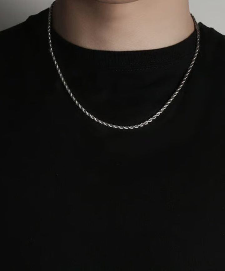 黒Tシャツの首元にジャストに収まるサイズ感と、ねじりデザインが生み出す立体的なボリューム感を正面から捉えたクローズアップカット。