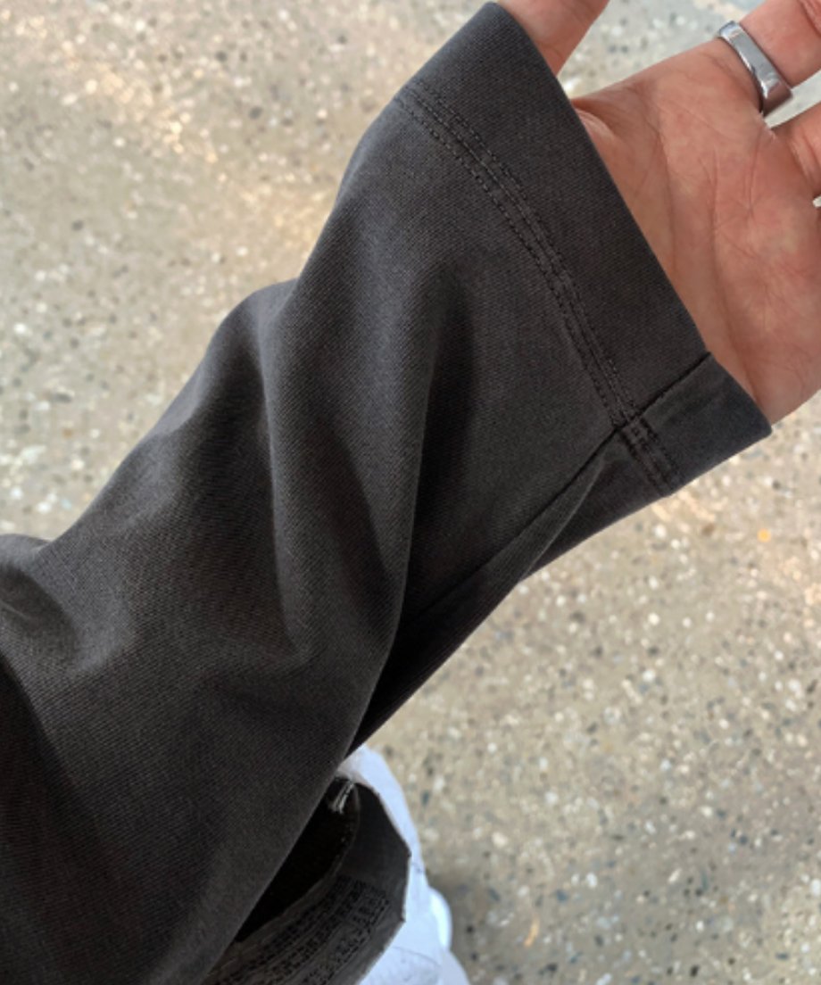 アイアングレーの長袖Tシャツの袖口（スリーブ）にフォーカスしたクローズアップカット。しっかりとしたダブルステッチの縫製と、ウォッシュド加工による絶妙な色ムラ・フェード感のある生地の質感が伝わるディテールカット。