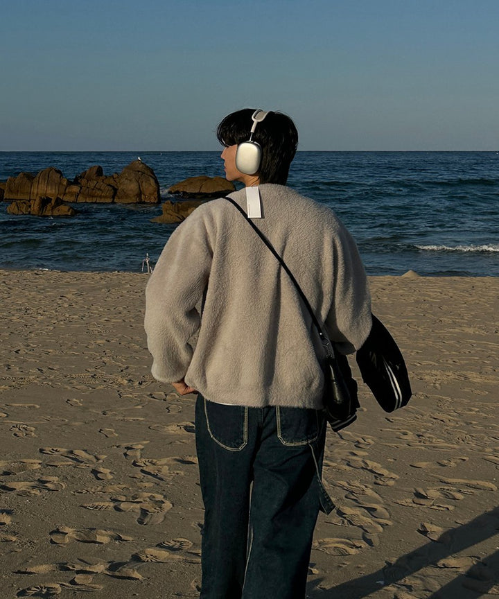 砂浜から広大な海を見つめる男性の後ろ姿を捉えたバックカット。