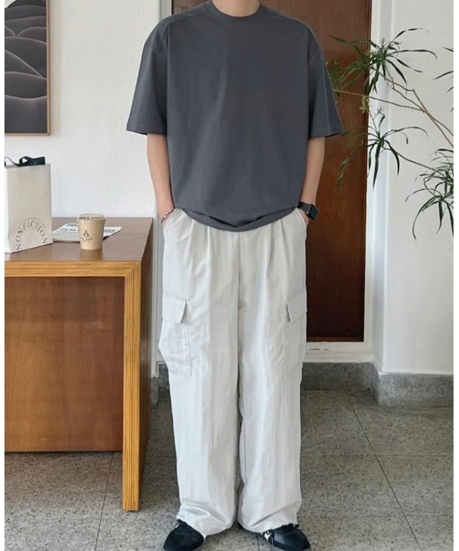 アイアングレーの半袖Tシャツを着用し、立つ男性の正面。