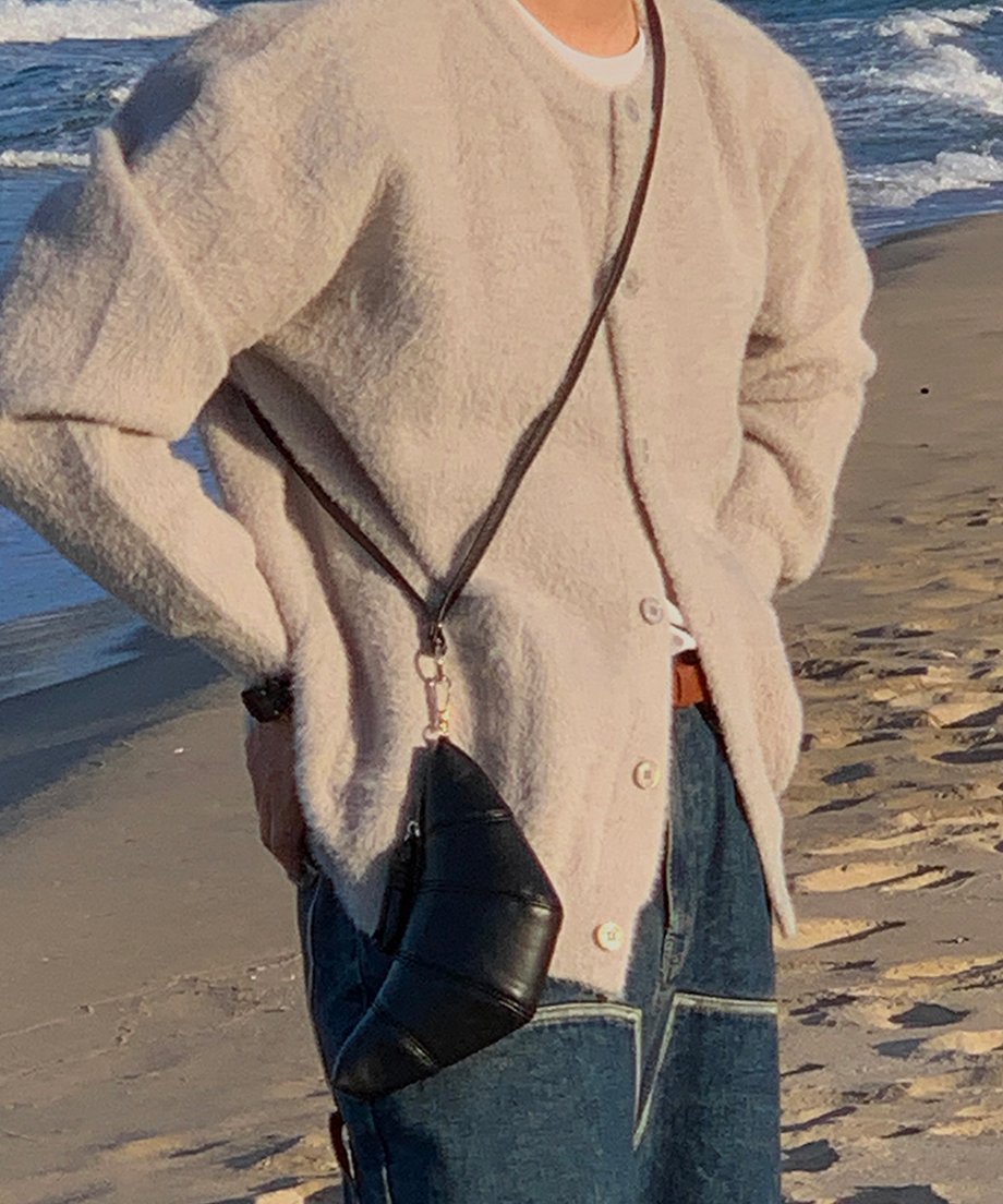 砂浜に立つ男性をサイドから撮影したカット。
