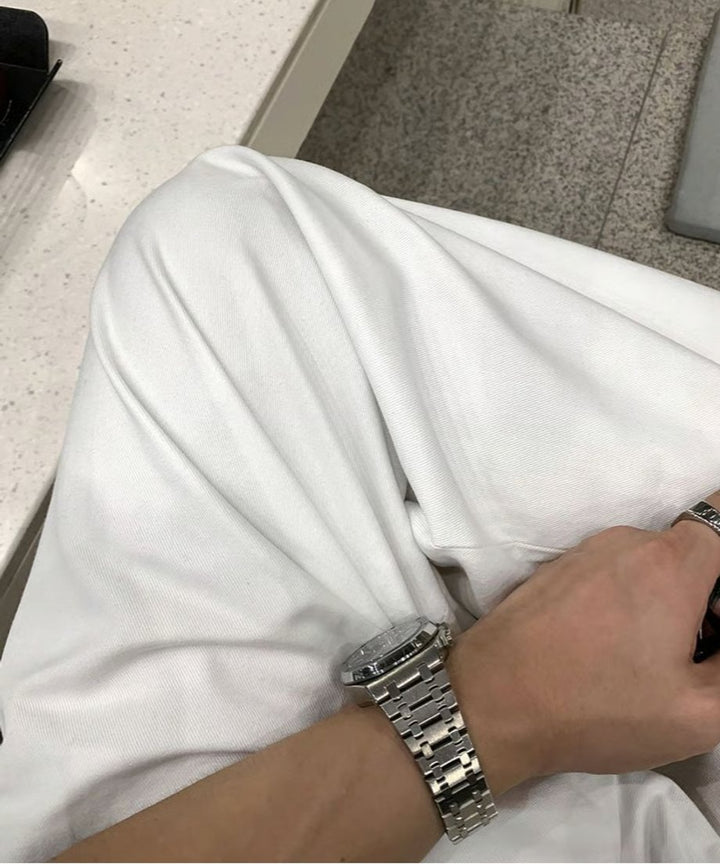 ホワイトのタックパンツを足を曲げたアップ。