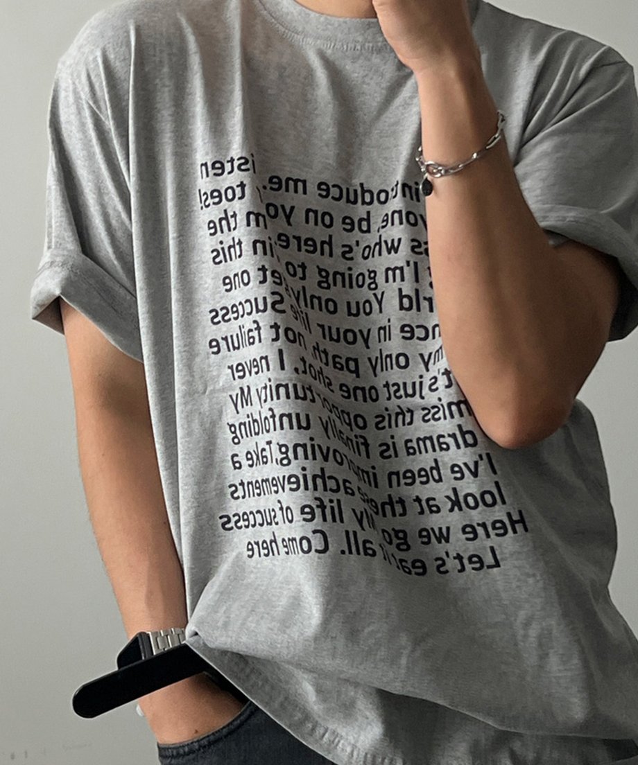グレーの半袖Tシャツに黒いボトムスを合わせた男性の上半身カット。