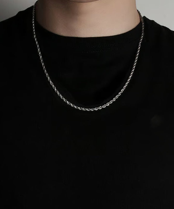 シンプルな黒Tシャツにシルバーのチェーンネックレスを合わせた、シンプルながらもエッジの効いたストリートモードなスタイリングの全体カット。
