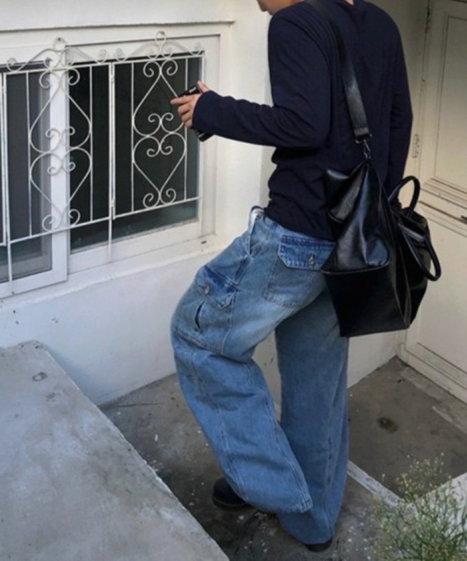 建物の階段を上る男性を後ろから捉えた、背面のフラップポケットとセンターのステッチラインが特徴的なブルーワイドレッグデニムのバックスタイル。