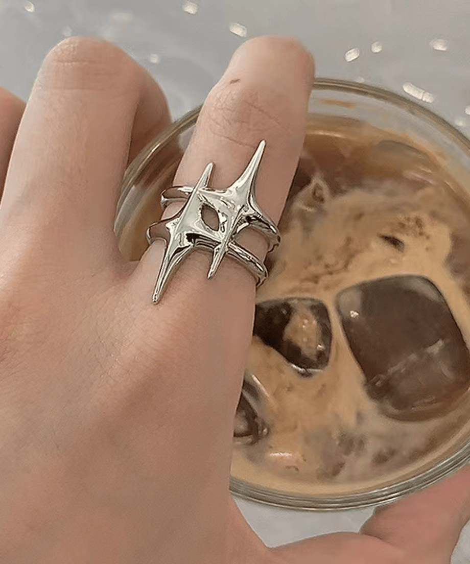 アイスコーヒーが入ったグラスを持つ手元カット。親指に着用されたリングが、都会的でモダンなカフェスタイルにエッジの効いたアクセントをプラス。