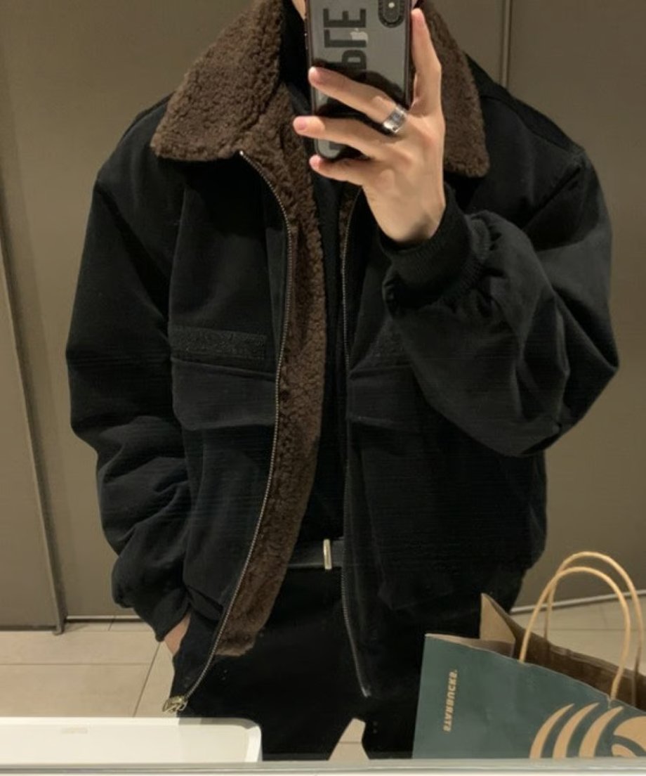 鏡に向かって両手でスマホを構えるフロントカット。ブルゾンの裾に施されたシルバーのダブルジップ（またはデザインジッパー）の金具が程よいアクセントになっている。