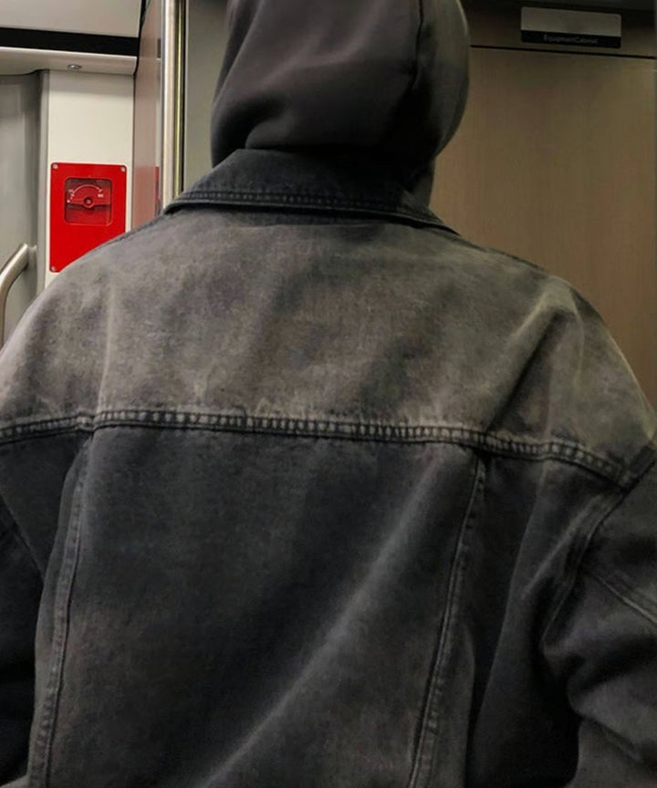 電車の連結ドア付近に後ろ向きで立つ男性のバックショット。背面のヨーク切り替えステッチや、ドロップショルダーによる広い肩幅、ウォッシュドデニム特有の背中の色落ちムラが特徴的。