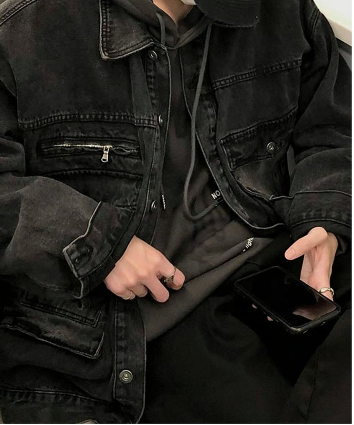 男性が椅子に座り、手元でスマートフォンを操作しているカット。肉厚なヘビーオンス生地ならではの、袖口や身頃のしっかりとした立体的なシワ・ドレープ感が表現されている。